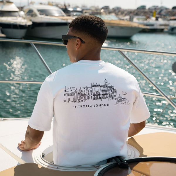 a man looking out to sea on a boat wearing a Tropez Official t-shirt