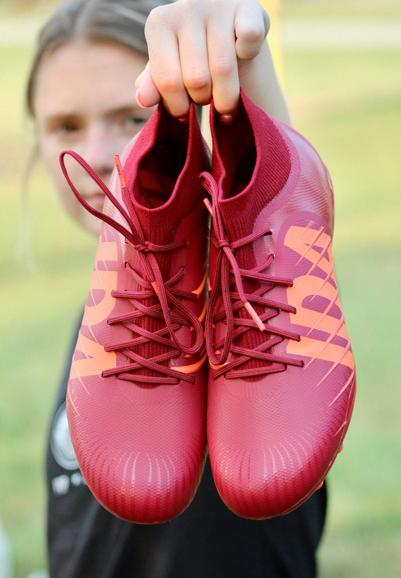 Player holding IDA Rise Women's Soccer Cleat, Burgundy, FG/AG, Firm Ground, Artificial Ground, Ankle sock