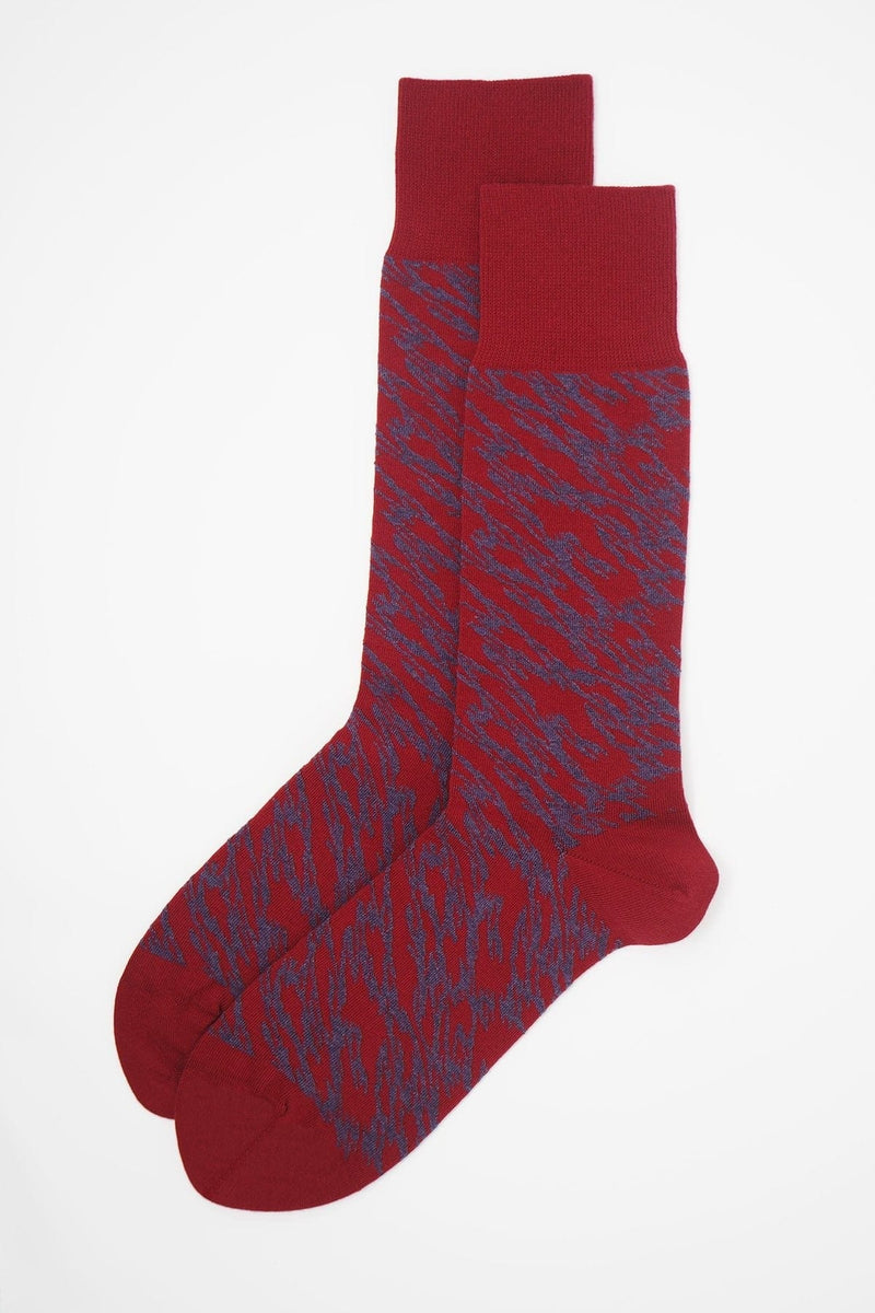 A pair of Pandemonium red men's luxury socks by Peper Harow, featuring a quirky purple pattern and purple toe and heel.