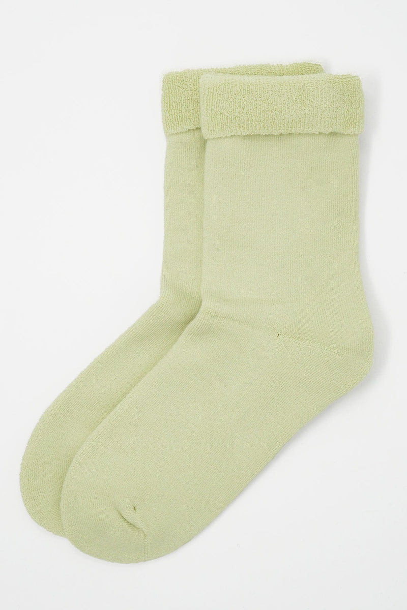 Two pairs of Peper Harow women's cream Plain luxury bed socks showing fluffy inside