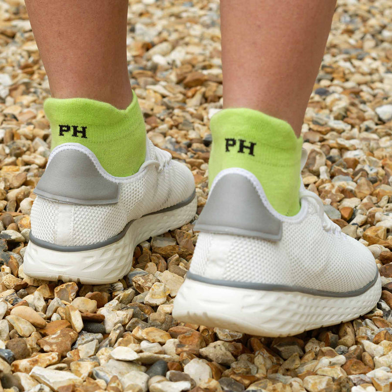 man wearing white trainers and Peper Harow neon green Organic men's luxury trainer sport socks