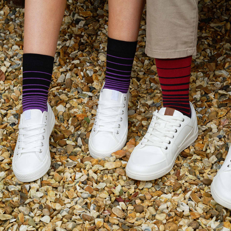 Woman sitting on a bench wearing Peper Harow Purple Retro Stripe women's luxury socks