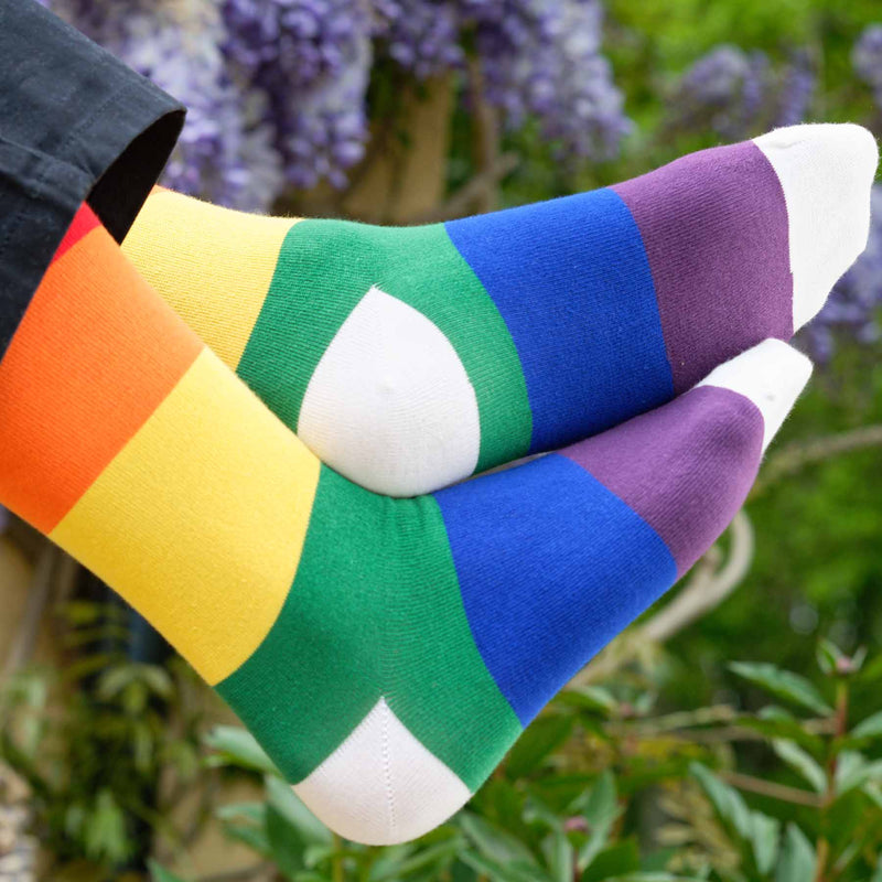 Man wearing black trousers and Peper Harow rainbow Block Stripe men's luxury socks