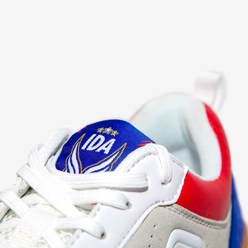 IDA Spirit Women's Indoor Soccer Futsal Shoe, White with Red & Blue accents, IC, Indoor Court, zoom in on the tongue with blue IDA design 